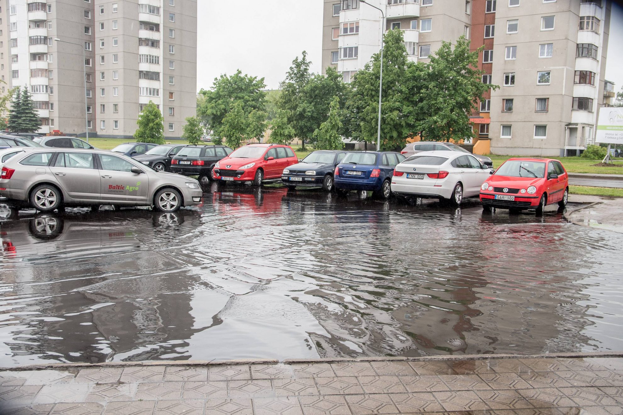 Prieš kelias dienas prie Panevėžio miesto poliklinikos naujai išasfaltuota automobilių stovėjimo aikštelė po pirmo lietaus atvėrė Savivaldybės darbo spragas