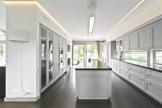 Lubų perimetras pabrėžiamas tarpukario interjerams būdingu lenktu profiliu - plastiška sienų bei lubų jungtimi ir paslėptu apšvietimu. „Sukuriamas jaukus, nepretenzingas apšvietimas be jokio stiklo, gaubto ar kitų įmantrybių, tiesiog sklindantis iš plyšio“, - paaiškina architektas.