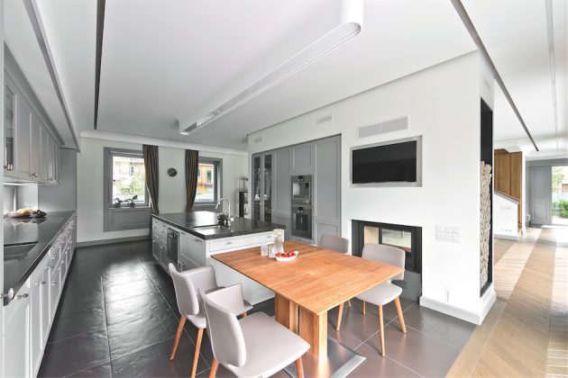 Virtuvės lubose, virš „salos“, įrengtas užglaistomas šviestuvas „Flos USP“. Architektas jį pasirinko kaip artimą sienų ir lubų profilio detalės formai. Saikingas šviestuvas neapsunkina interjero, tiesiog skleidžia santūrų, tačiau ne vien šaltą techninį apšvietimą.