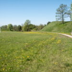 Iš trijų pusių Liaudės upės apsuptas, iš šiaurės pylimo saugomas, stačiais šlaitais įrėmintas Bakainių piliakalnis su savo pylimais, priešpiliu ir papiliu vienu žvilgsniu neaprėpiamas. T. ŠIAUDINIO nuotraukos