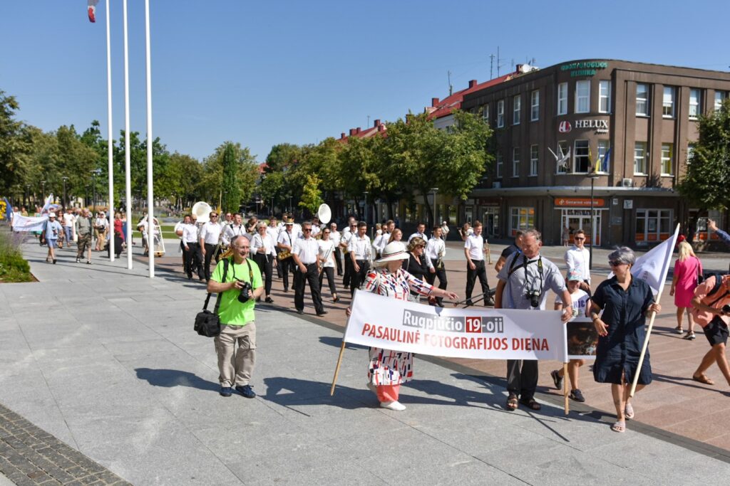 Laisvės aikštėje penktadienio vidudienį praeivių akis traukė spalvinga eisena, kurioje pagrindinis akcentas buvo ne balionai, plakatai ar gėlės, o … fotoaparatas.