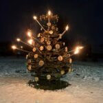 Iš surūdijusių senų kastuvų Rimanto Kielos pagamintą eglę nušvietė deglai. R. KIELOS asmeninio archyvo nuotr.