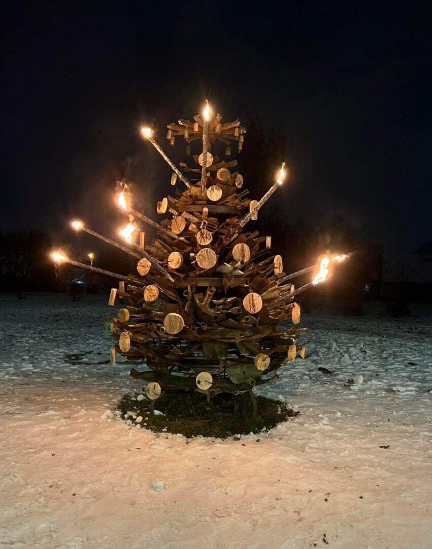 Iš surūdijusių senų kastuvų Rimanto Kielos pagamintą eglę nušvietė deglai. R. KIELOS asmeninio archyvo nuotr.