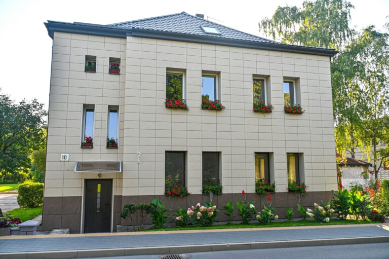 Keliaujantieji A. Jakšto gatve nejučia sulėtina žingsnį ties 10-uoju numeriu pažymėtu daugiabučiu. Akį patraukia kaskados nuo palangių svyrančių žiedų, namą supantys ištaigūs gėlynai.