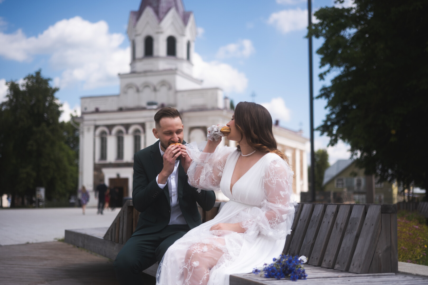 Vestuvinio albumo „vinimi“ neabejotinai tapo nuotrauka, kurioje jaunieji ant suoliuko prie bažnyčios valgo mėsainius. S. BARONO nuotr.