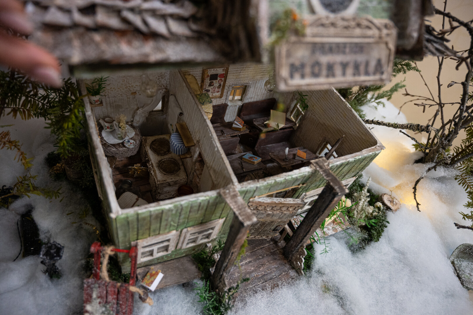 Visų miniatiūrinių namelių viršus atsivožia, įsižiebia šviesa ir atsiveria buitis, kokioje lietuviai sukosi prieš šimtą metų. P. ŽIDONIO nuotr. 