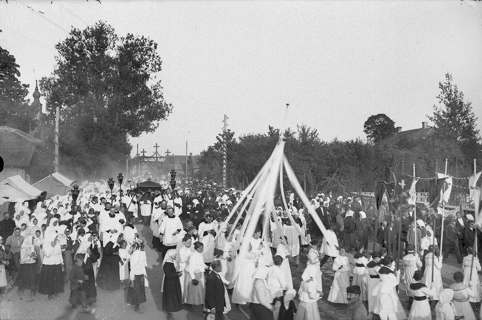 Miežiškių bažnyčios konsekravimo iškilmės. 1921 m. Fot. V. Firinauskas. Iškilmių dalyviai eina iš senosios medinės bažnyčios (matyti bokštelis) į naująją. Tolumoje matyti apsilankiusio vyskupo Pranciškaus Karevičiaus garbei pastatyti vartai.